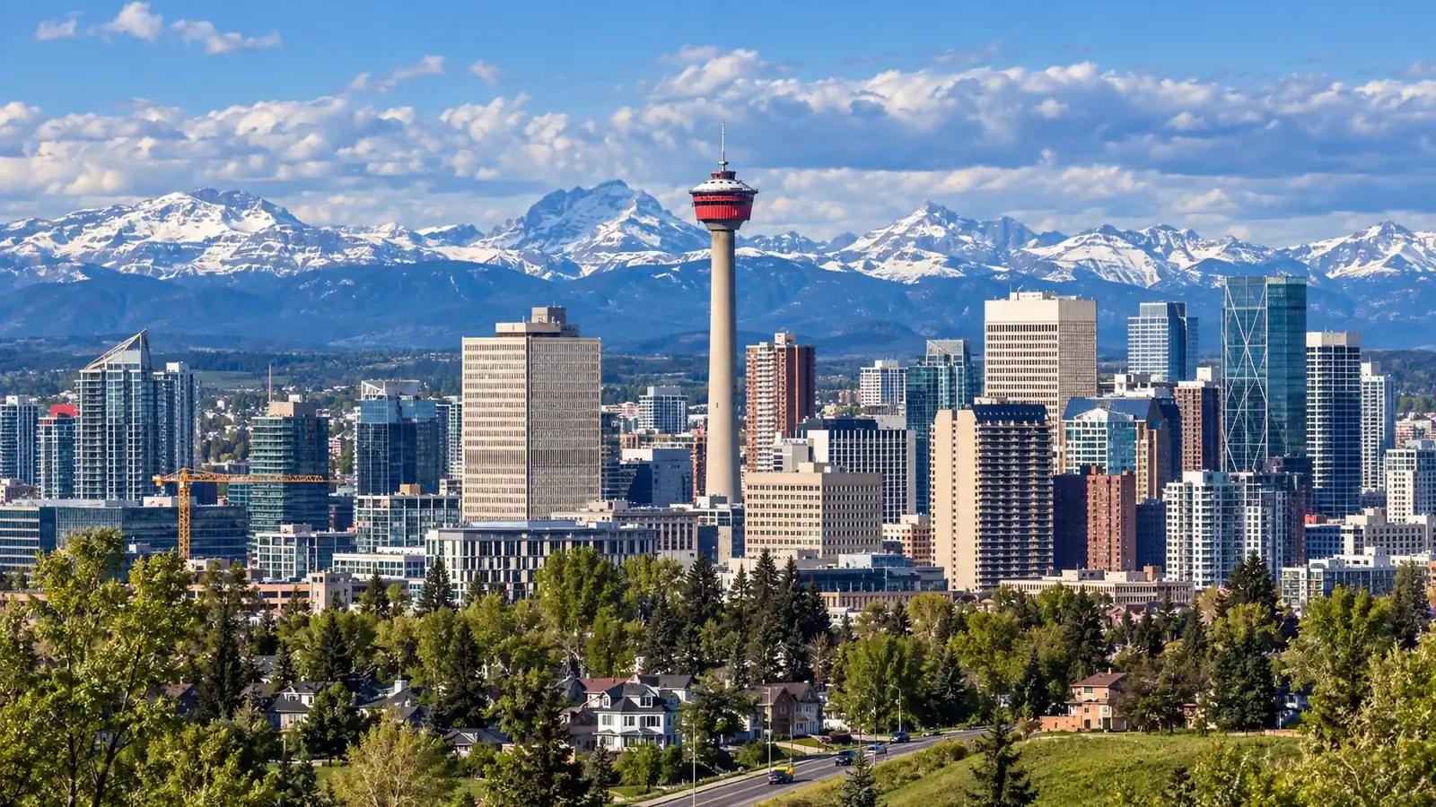 Moving to Calgary: the downtown skyline and the Calgary Tower, with the snow-capped Rocky Mountains behind