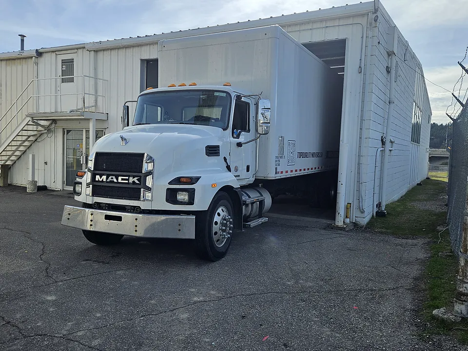 White box truck backed into a storage facility's loading bay