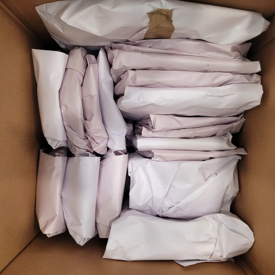 Packing tips for moving: kitchen items wrapped one at a time in packing paper, packed tight in a box