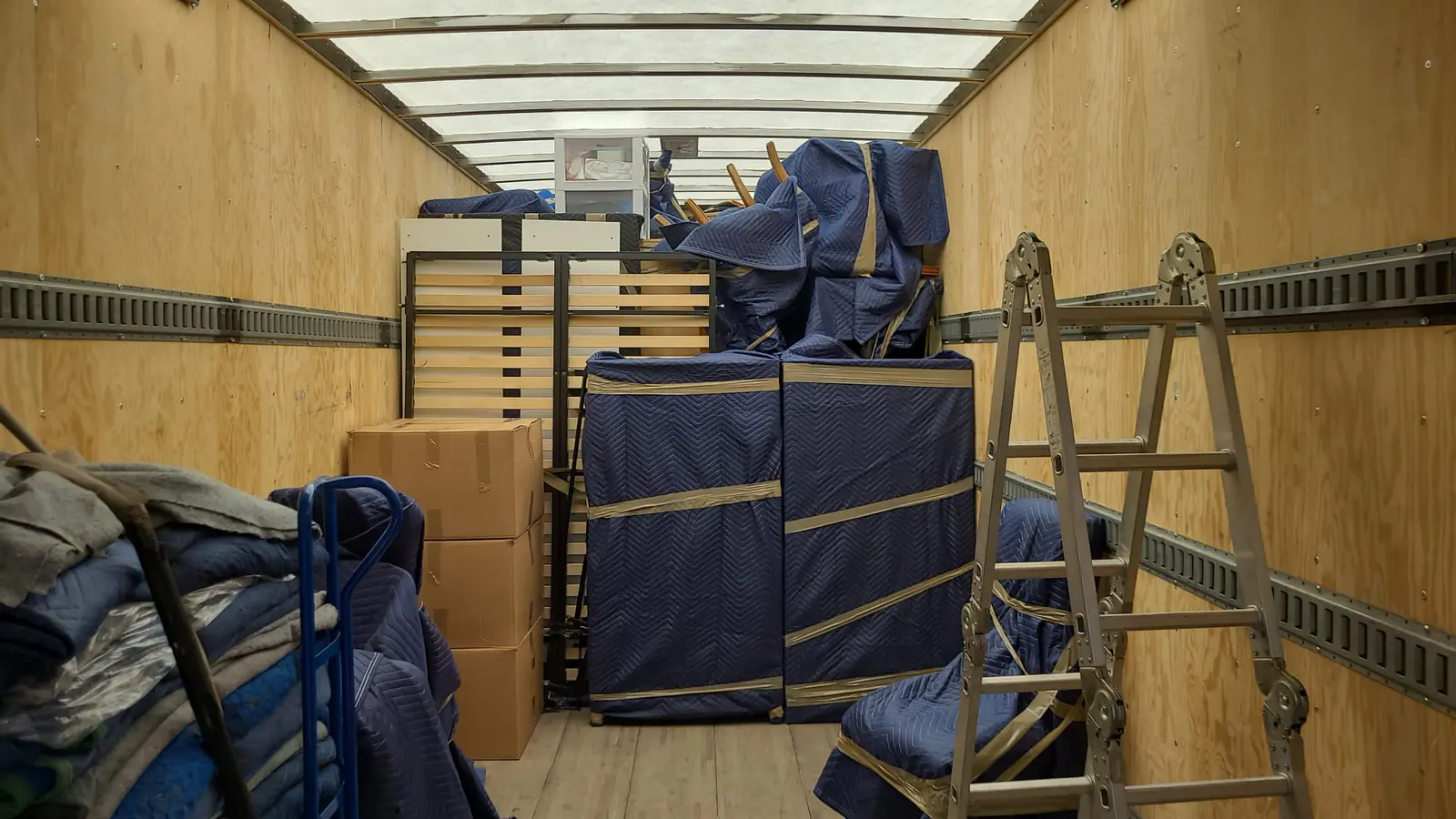 Moving house: furniture wrapped in moving blankets and stacked inside the truck