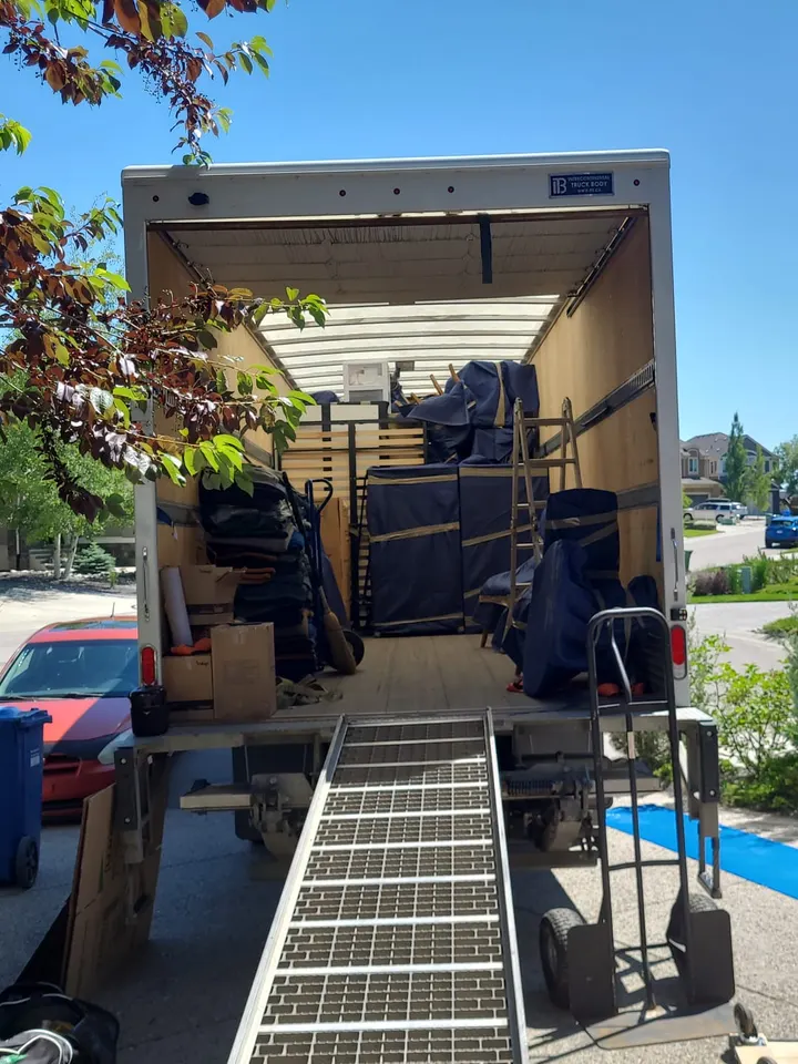Moving day: furniture wrapped in moving blankets inside the truck, with the loading ramp down